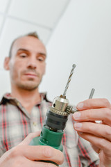 Naklejka premium Young worker using a drill