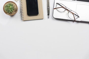 Office desk table with computer, supplies, cactus,glasses,working place elements on white table with a lot of things on it. Top view with copy space.selective focus