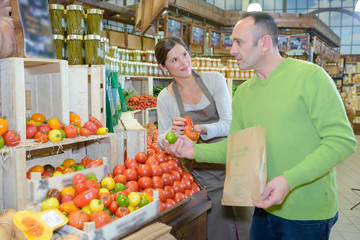 Man choosing tomatoes in store