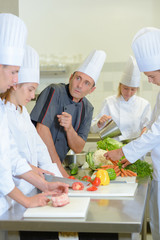 Chef instructing trainee caterers
