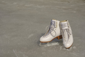 White figure skates on the spring ice in sunny day
