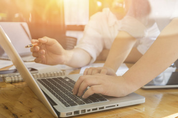 Fototapeta premium Business and finance meeting,partnership.young businessmans crew working with new startup project in modern office.Contemporary smartphone, laptop wood table.selective focus vintage color..