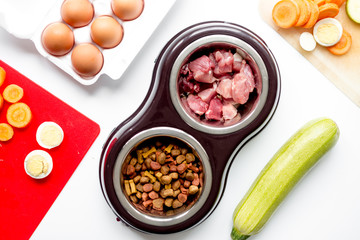 food for pets with meat and eggs on kitchen background top view
