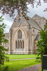 Fototapeta na wymiar Pluscarden Abbey in Scotland with green grass and trees
