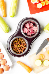 Dogfood set with cut vegetables and knife on table background top view