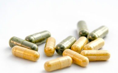 Żółte i zielone tabletki na białym tle