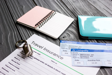 Traveling concept with insurance application and passport on wooden table