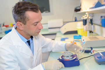 Lab technican setting up small centrifugal machine