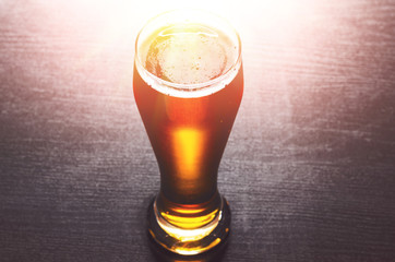 glass of fresh lager beer on black table
