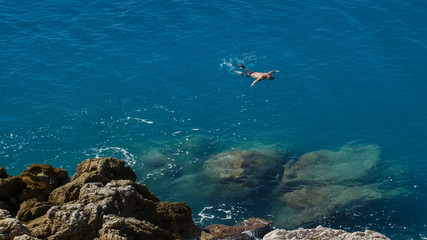 Upper view man swim in transparent tranquil turquoise Mediterranean sea.