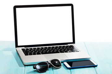 Work on the go. Modern laptop computer with smartphone and sunglasses on blue table