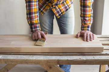 Applying protective varnish on wooden floor