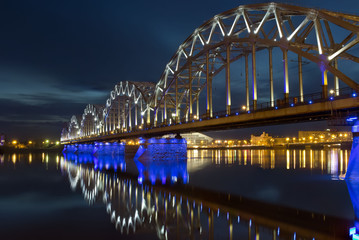 Night panoramic scene with railway bridge in Riga.