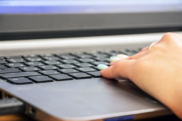 Woman's hand on laptop keyboard. Selective focus