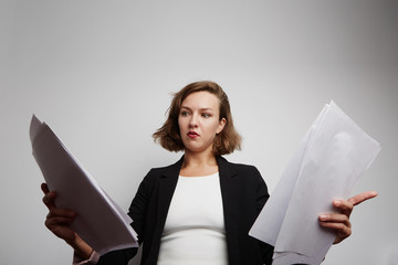 Perplexed accountant doing financial reports holding documents.