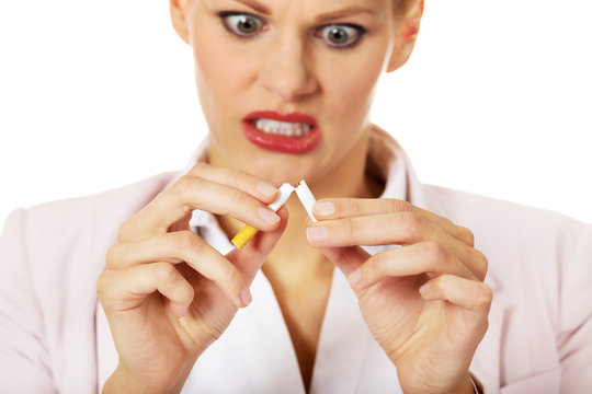 Agressive business woman breaking cigarette