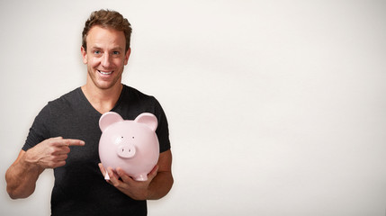 Smiling man with piggy bank.
