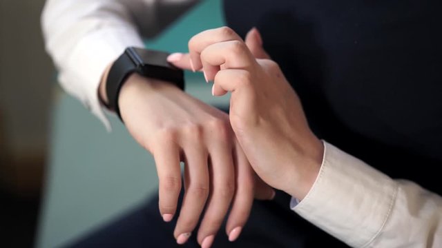 Close up shot of a business lady hands, who uses a new gadget, which is called a smart watches. This fits to the costume of a woman, gives her a style with a status.