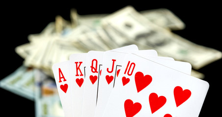 Combination of playing card on dollar background.