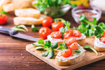Bruschetta with ricotta, spinach, corn salad and cherry tomatoes