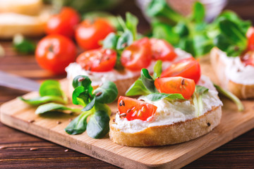 Bruschetta with ricotta, spinach, corn salad and cherry tomatoes