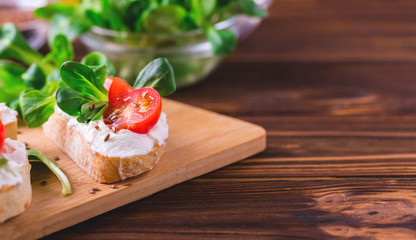 Bruschetta with ricotta, spinach, corn salad and cherry tomatoes
