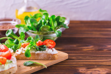 Bruschetta with ricotta, spinach, corn salad and cherry tomatoes