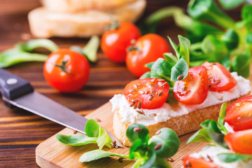 Bruschetta with ricotta, spinach, corn salad and cherry tomatoes