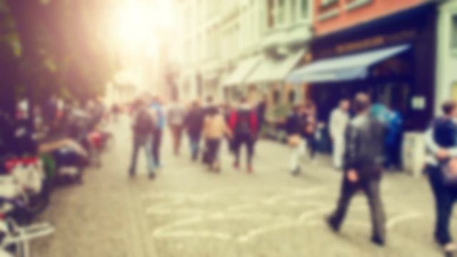 Blurred anonymous crowd of people walking European city street
