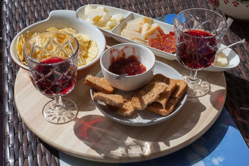 Antipasto of jam, salami, cheese, potatoes and red wine