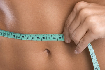 Female belly with a measuring tape