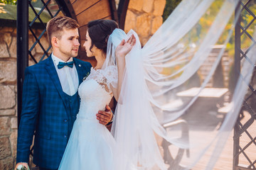 Wedding couple embracing near wall with copy space. Bride and groom in love at wedding day