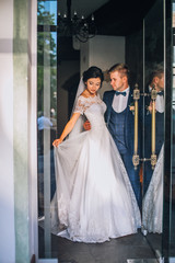 Bride and groom near glass door display