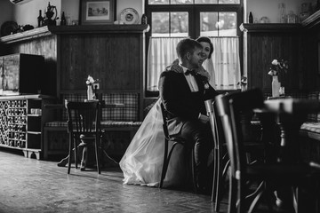 Cute married couple in cafe, bride kissing a groom . Pure tenderness