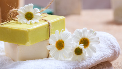 Obraz na płótnie Canvas Handmade soap bars and chamomile on wooden background