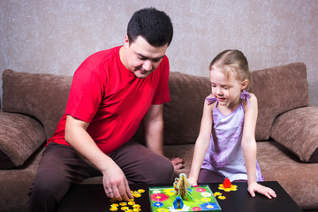Dad and daughter playing table game