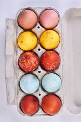 Multi colored eggs in container. Dyed Easter eggs, top view.
