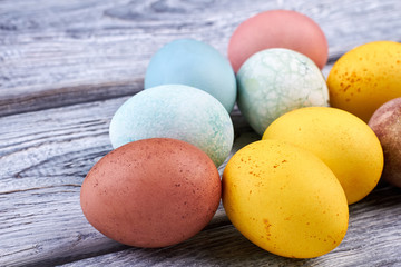 Colored eggs on wooden surface. Bright Easter eggs close up.