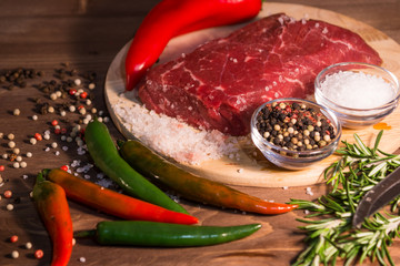 Сырой кусок говядины с овощами, розмарином, солью и...