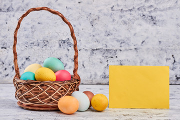 Basket with easter eggs. Blank yellow paper. Holiday of Christ.