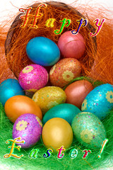 Happy Easter. Colorful Easter eggs in a basket on the artificial grass and Text Happy Easter