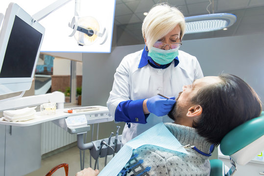 Dentist lady working with patient. Examination at dentist office. Medicine and healthcare.
