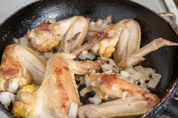 Fried chicken wings in a frying pan