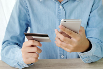 Woman hands using smart phone and holding credit card, shopping online concept, business and technology
