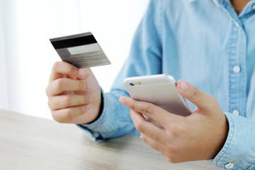 Woman hands using smart phone and holding credit card, shopping online concept, business and technology
