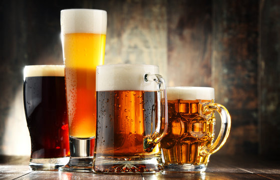 Four glassed of beer on wooden background