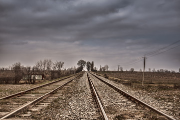 Fototapeta na wymiar Rails (dormitories) at the electrified railway corridor. Cloudy weather. Gazakh Azerbaijan