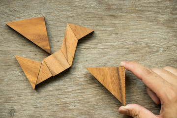 Man hold triangle to fulfill tangram puzzle in bird shape (Concept for freedom, free life or explore new world)