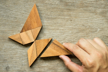 Man hold triangle to fulfill tangram puzzle in butterfly shape (Concept for freedom, free life or explore new world)