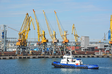 Fototapeta premium Tugboat and port cargo crane
